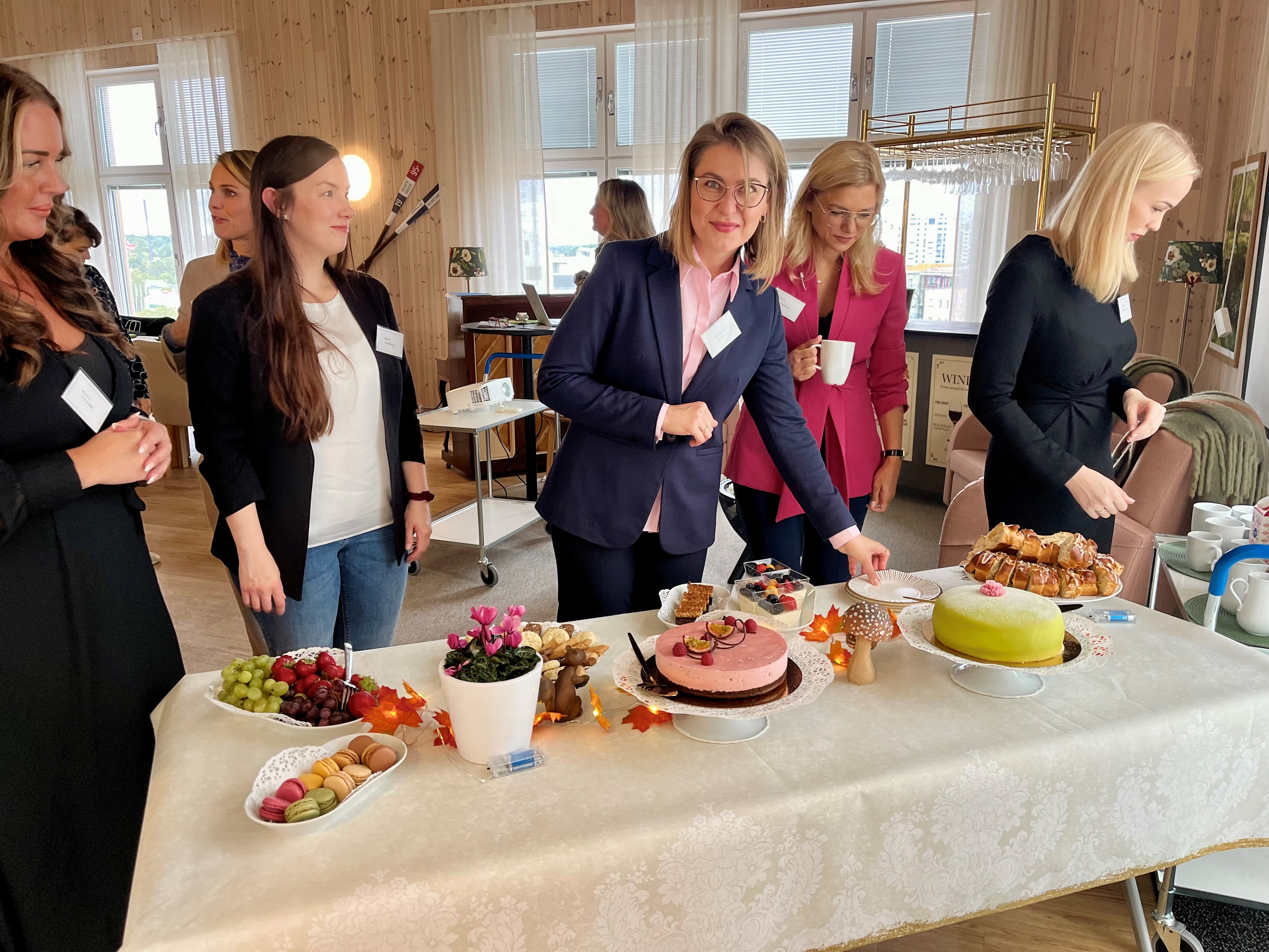 Eventdeltagare tar tårta på ett härligt uppdukat fikabord.