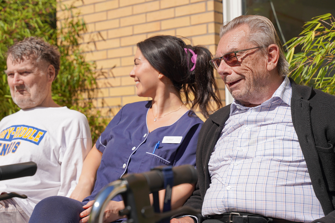 Demenssjuksk&ouml;terska och tv&aring; boende i h&auml;rligt samtal utomhus