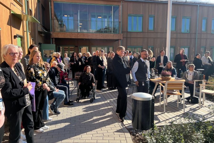 Besökare av invigningen lyssnar till en talare.