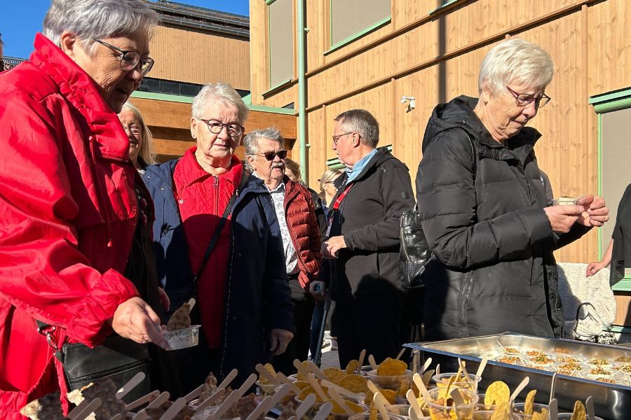 Besökare minglar i solskenet utanför Tunagården.