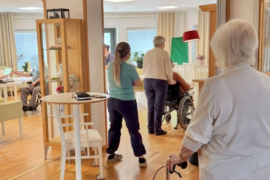 Äldre köar i ambulerande vallokal för att rösta, med hjälp av personal