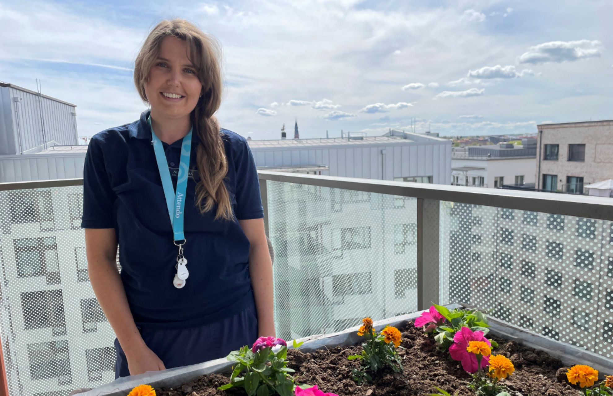Sjuksk&ouml;terskan Alexandra p&aring; balkongen med fin utsikt och blommor i planteringsl&aring;da