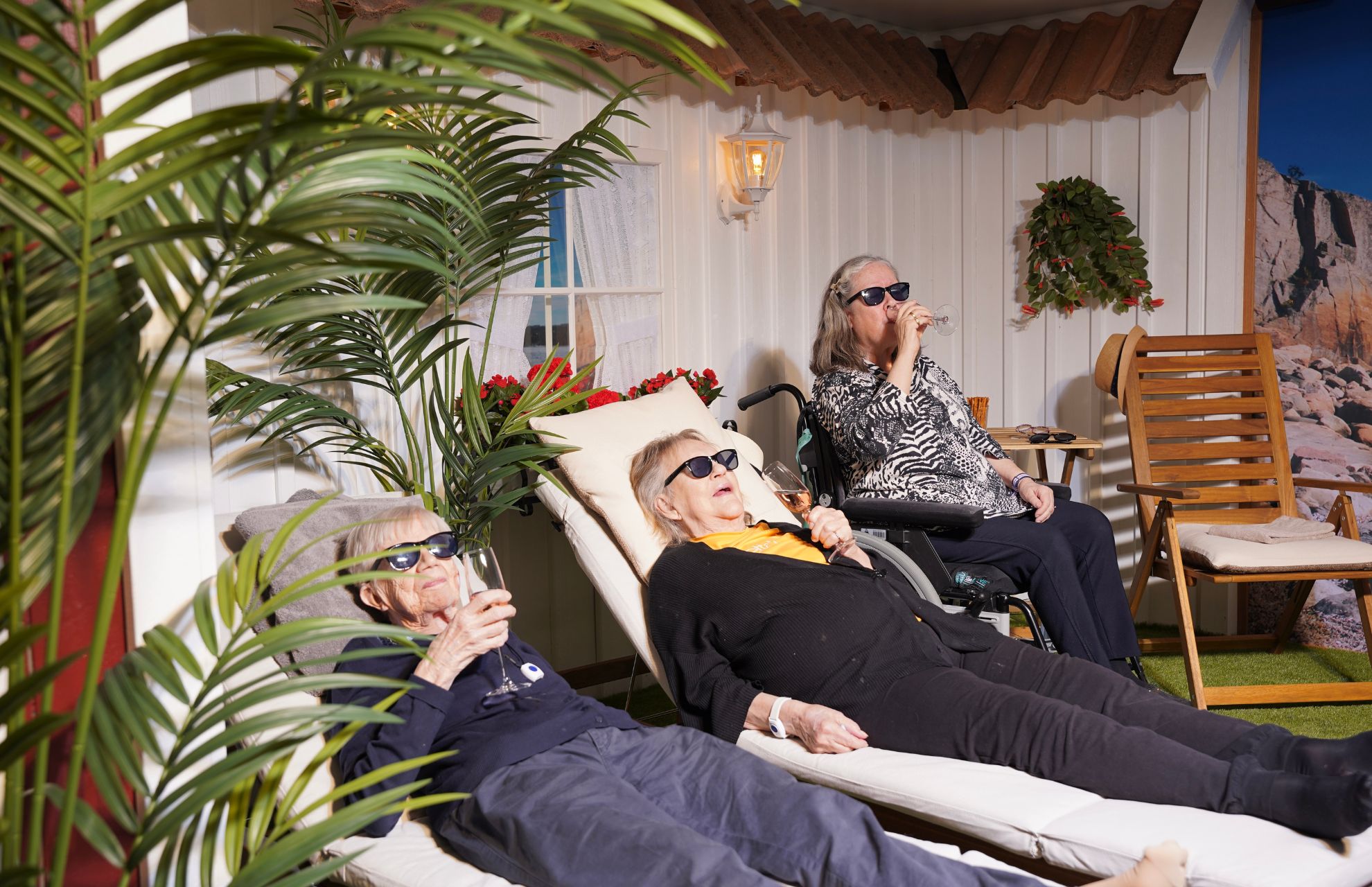 Tre kvinnor solar och dricker bubbel i Attendo Näsbyterrassens solrum