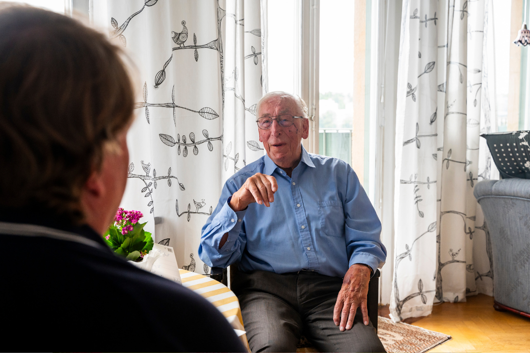 Äldre man sitter i sitt hem och samtalar med en medarbetare från Attendo